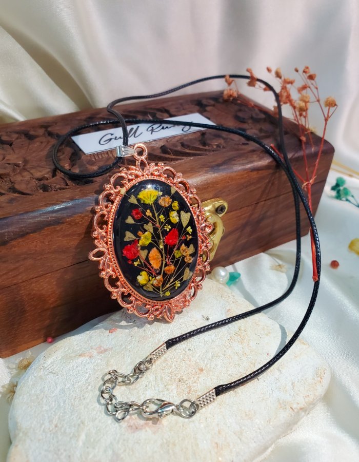 Close-up of the Zar-e-Rung resin jewelry pendant on a Gullrung-branded wooden presentation box