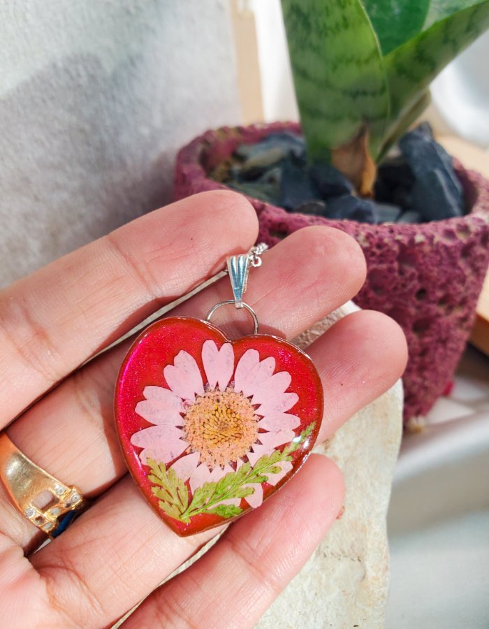 Mah‑e‑Dil Gulabi Red Daisy Heart Pendant – handmade heart flower pendant, held in hand to show size