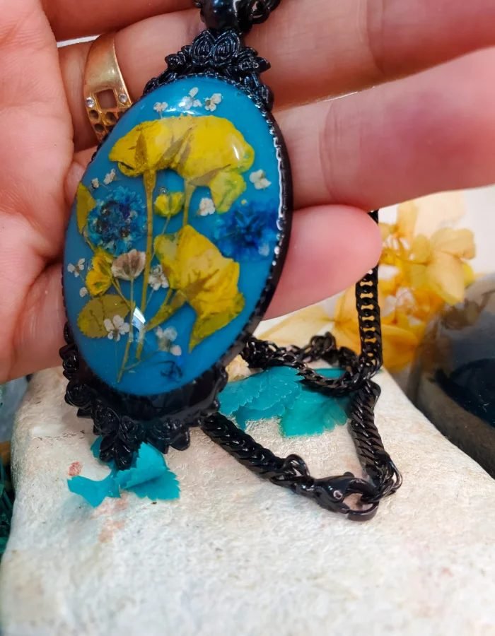 Resin vs gold jewelry: Gullrung real flower resin pendant with ornate black frame and black chain